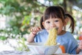 HappyÃ¢â¬â¹ AsianÃ¢â¬â¹ childÃ¢â¬â¹ girlÃ¢â¬â¹ enjoyÃ¢â¬â¹ eatingÃ¢â¬â¹ someÃ¢â¬â¹ noodles byÃ¢â¬â¹ herself.Ã¢â¬â¹ HealthyÃ¢â¬â¹ FoodÃ¢â¬â¹ andÃ¢â¬â¹ kidÃ¢â¬â¹ concept